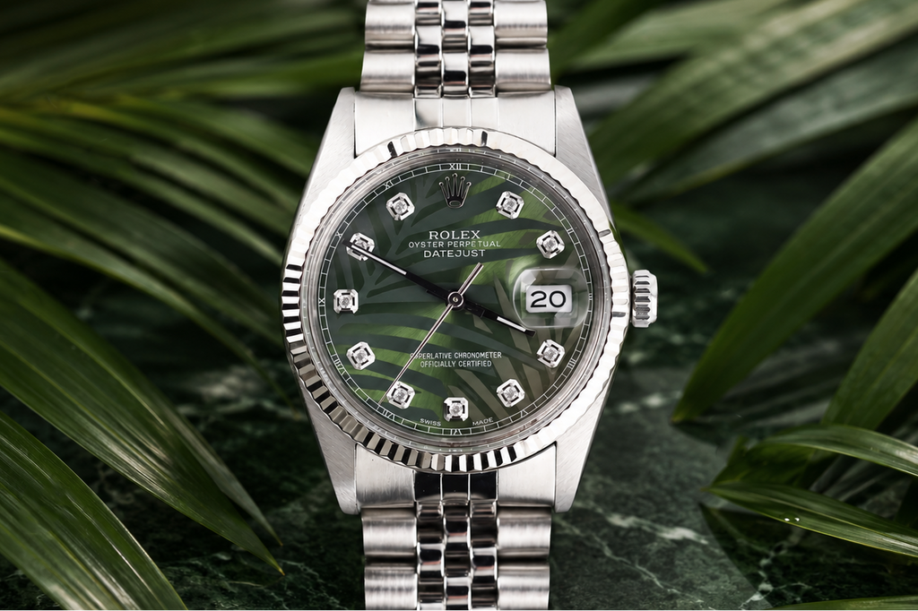 Silver watch with a green dial on a leafy background