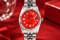 Silver watch with a red face on a red background