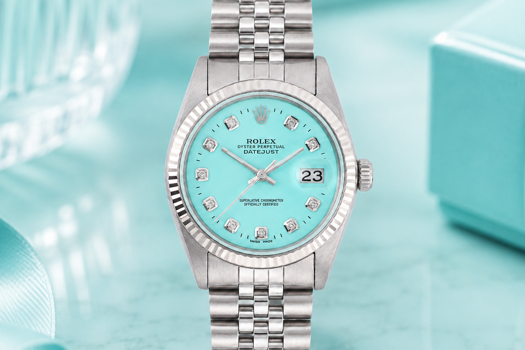 Silver watch with a turquoise dial on a light blue background