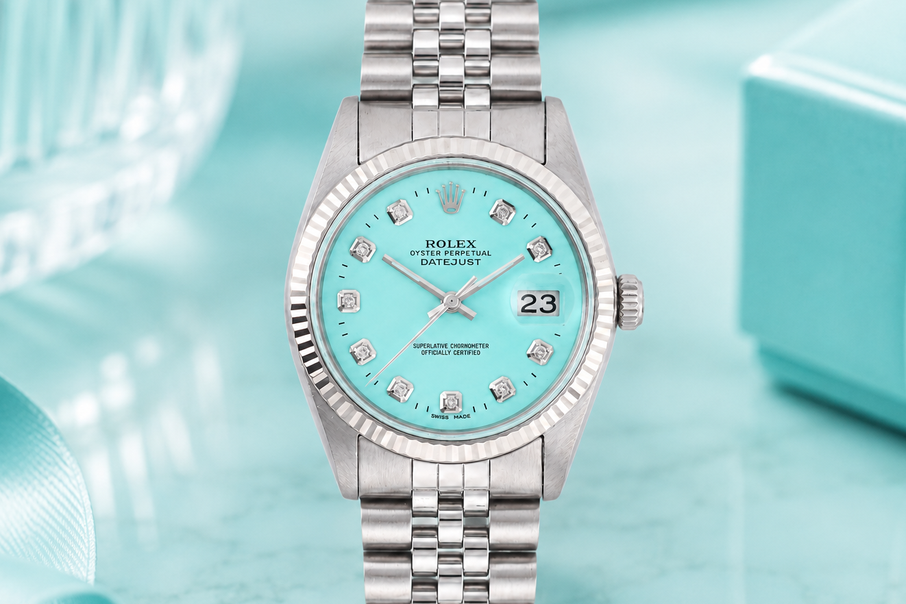 Silver watch with a turquoise dial on a light blue background