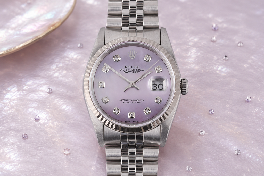 Silver watch with a purple face on a mother of pearl background