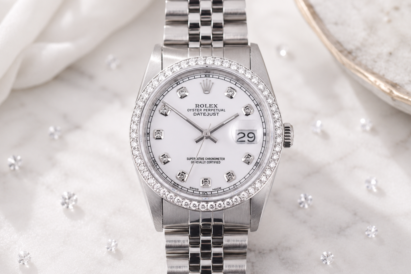 Silver watch with diamond-studded bezel on a marble surface