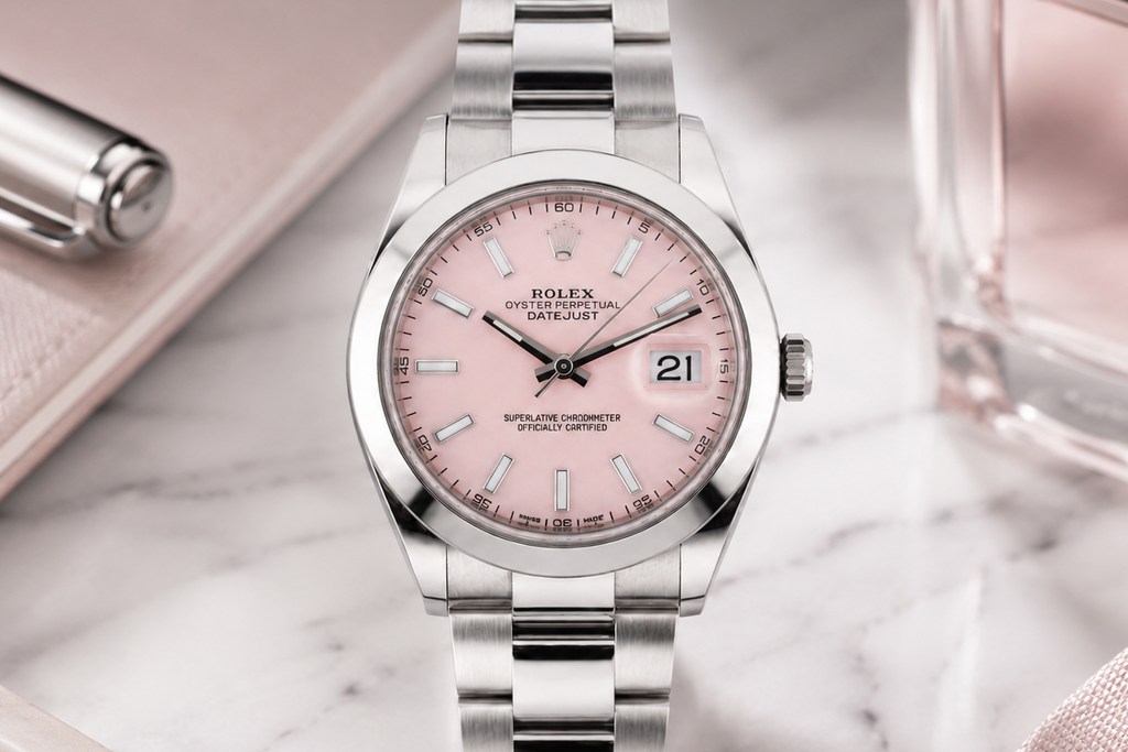 Silver watch with a pink face on a marble surface