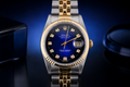 Luxury watch with blue dial and gold accents on a dark background
