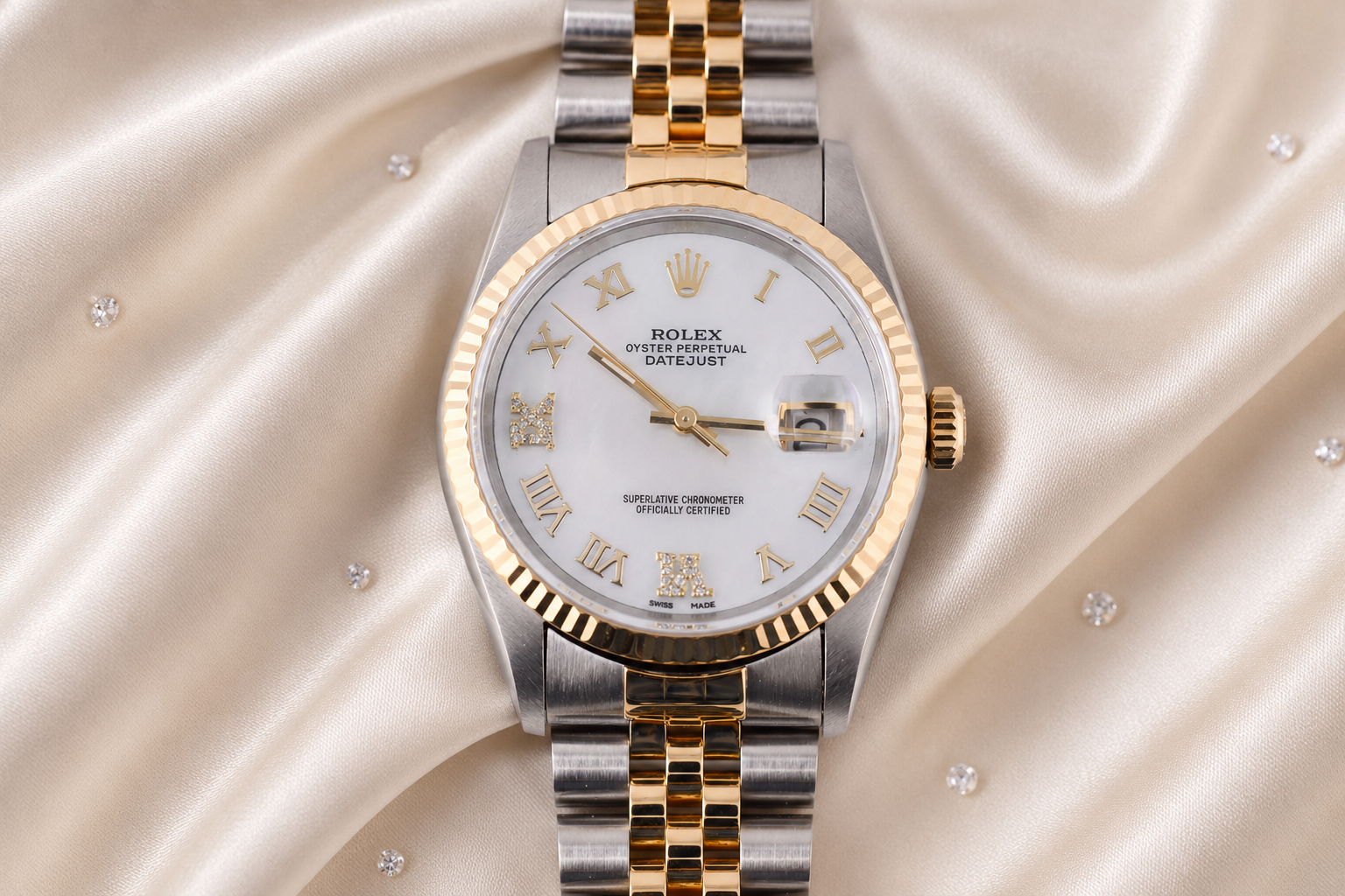 Luxury watch with silver and gold band on a soft fabric background