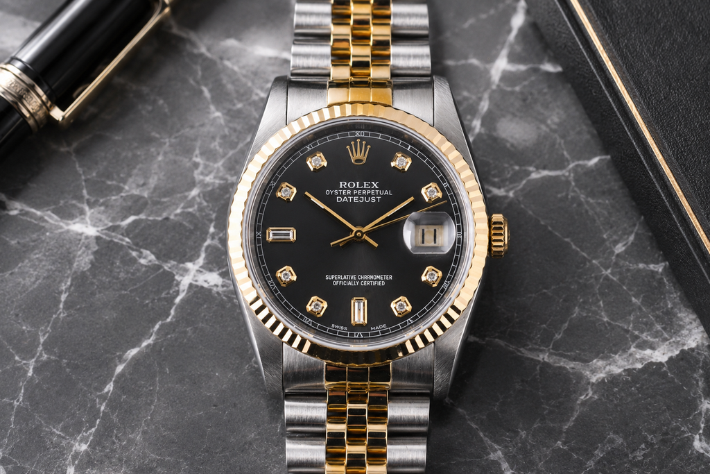 Luxury watch with black dial and gold accents on a marble surface