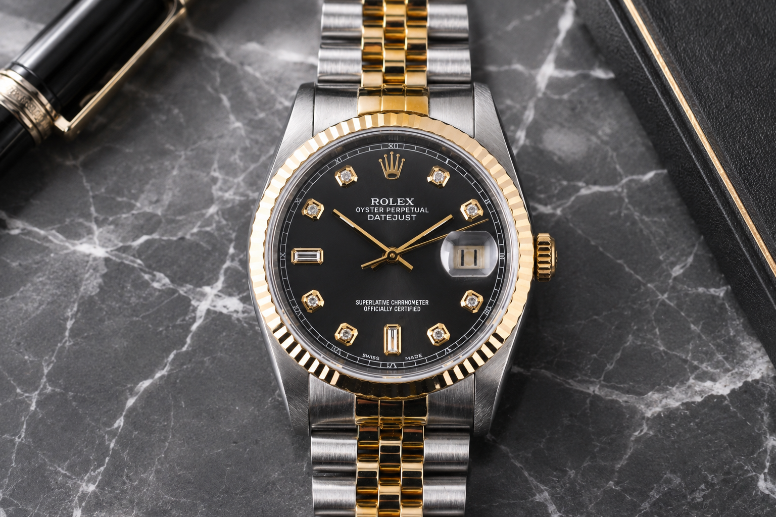Luxury watch with black dial and gold accents on a marble surface