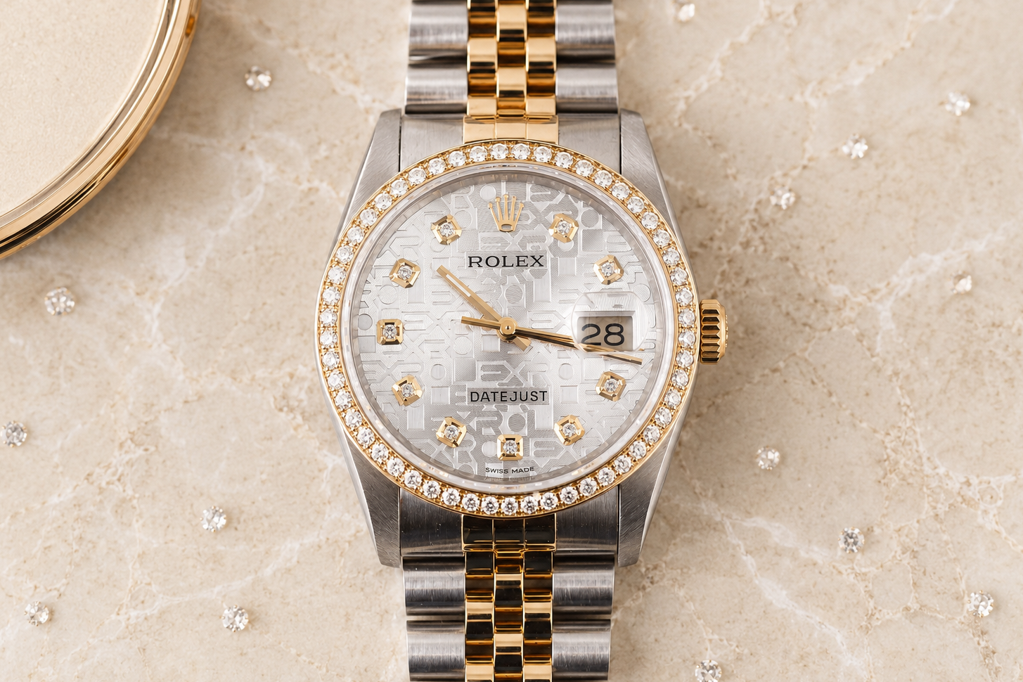 Rolex watch with a two-tone gold and silver band on a textured surface
