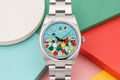 Colorful watch with a unique face on a multicolored geometric background