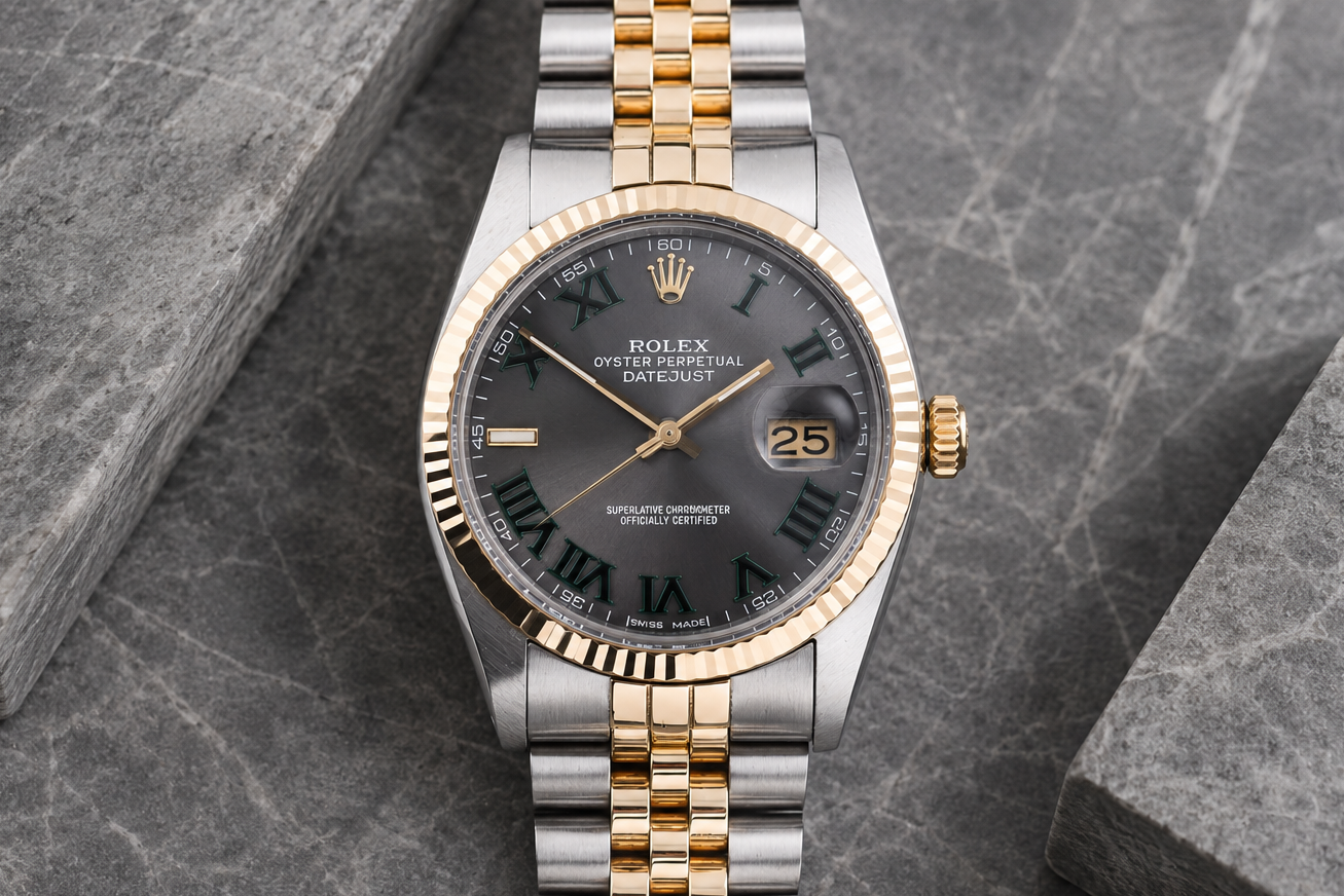 Rolex watch with two-tone gold and silver bracelet on a gray stone surface