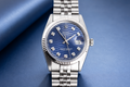 Silver watch with a blue face on a blue background