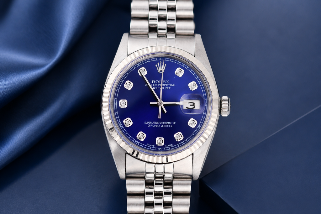 Silver watch with a blue dial on a dark blue fabric background