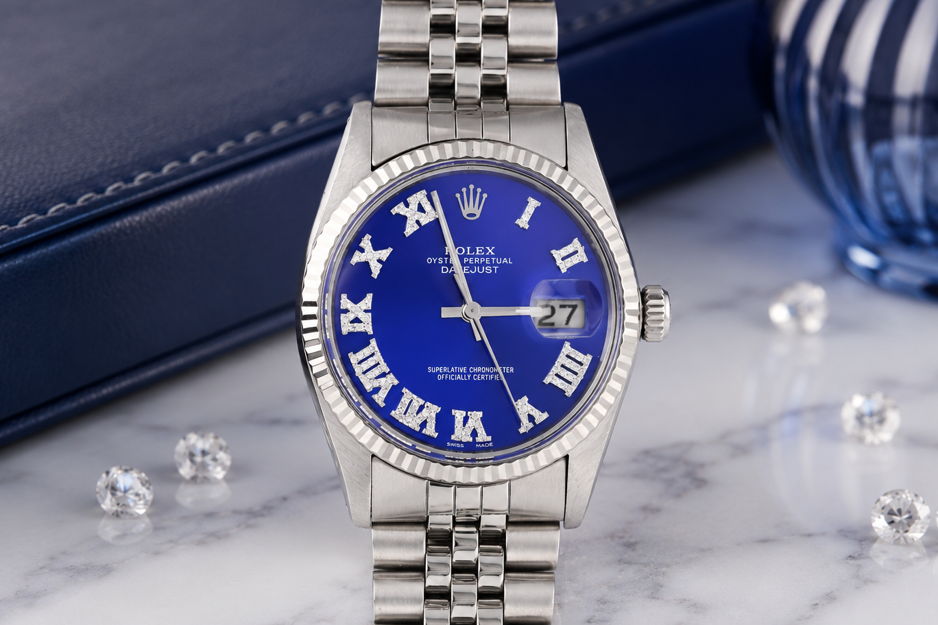 Silver watch with blue face on a marble surface with diamonds