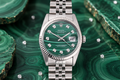 Silver watch with a green face on a green malachite background