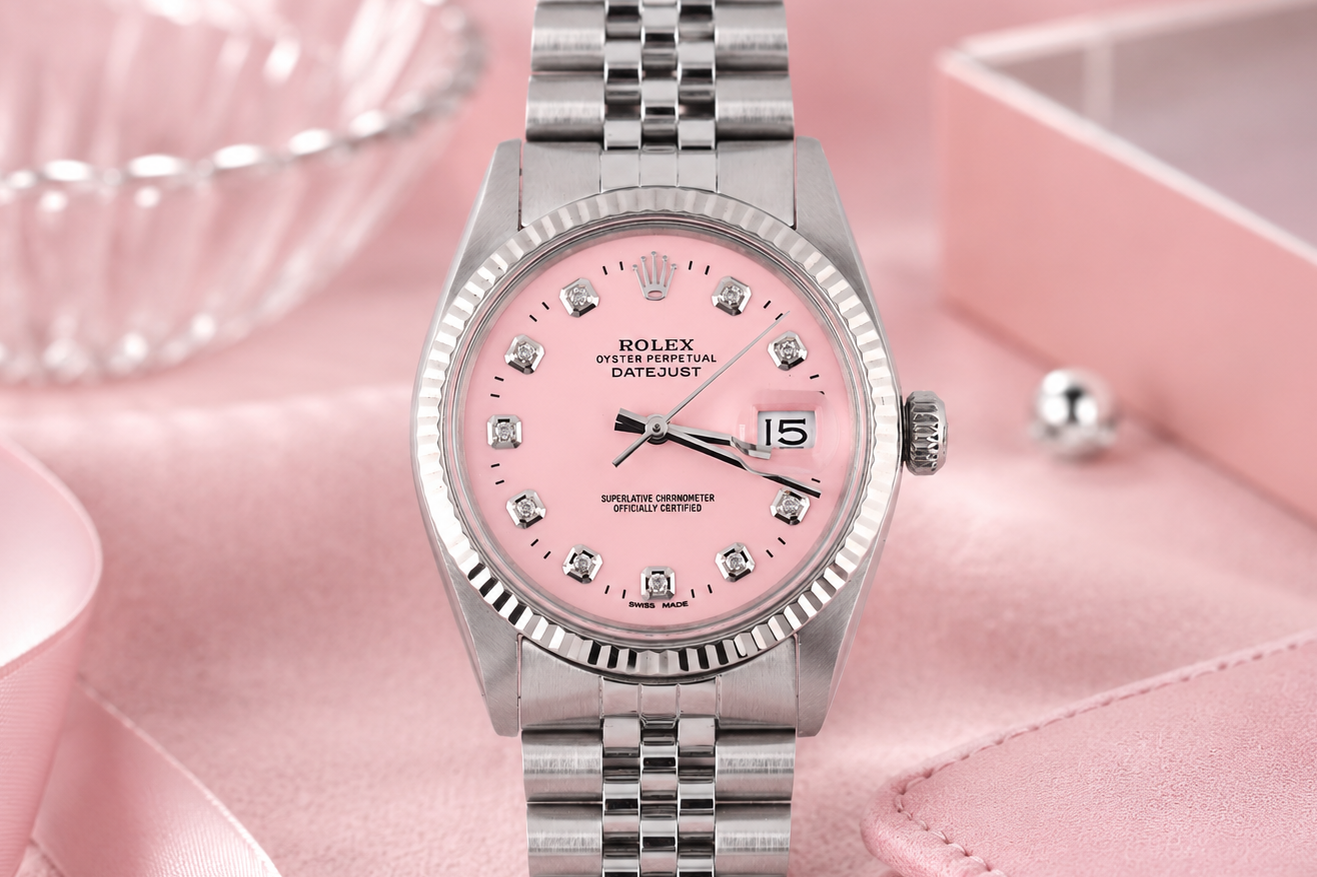 Silver watch with a pink face on a pink background