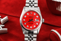 Silver watch with a red face on a red background
