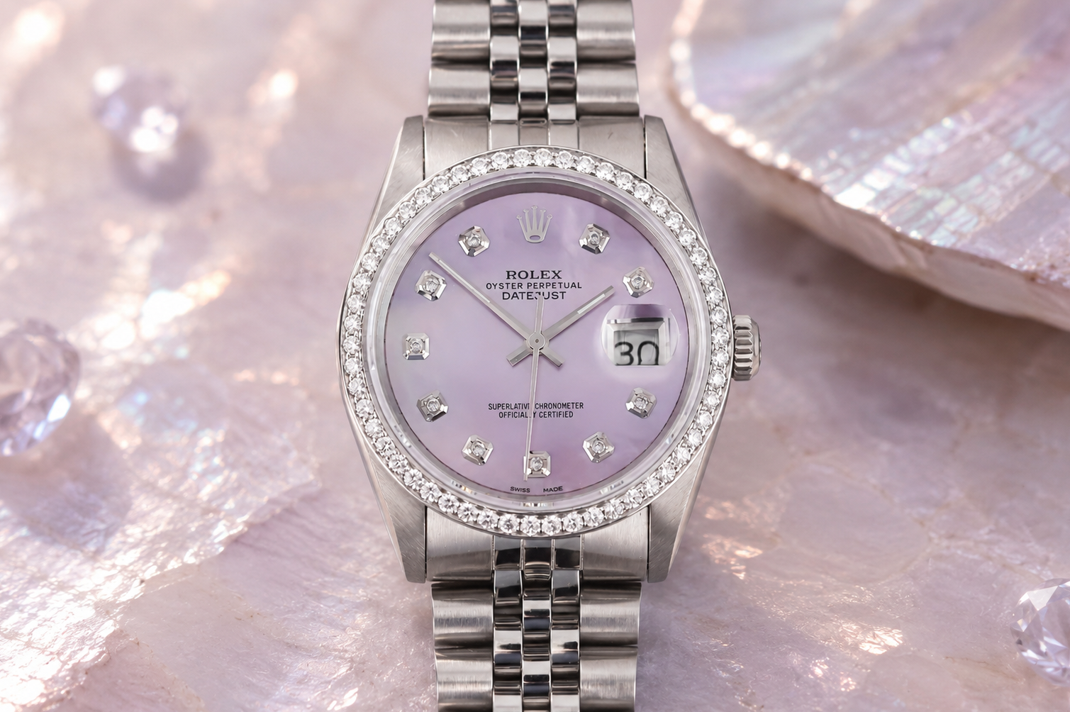 Silver watch with a purple face on a textured surface