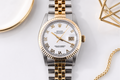 Luxury watch with gold and silver band on a white background
