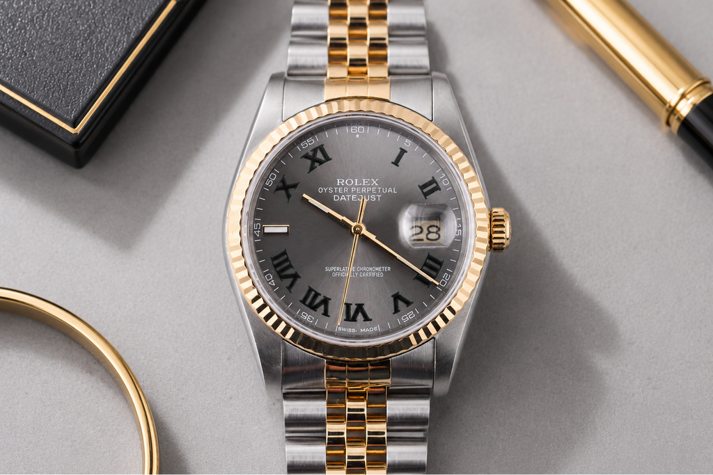 Luxury watch with gold and silver band on a gray surface