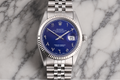 Silver watch with a blue face on a marble background