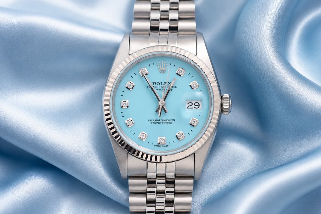 Silver watch with a blue face on a blue satin background