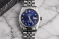 Silver watch with a blue face on a marble surface