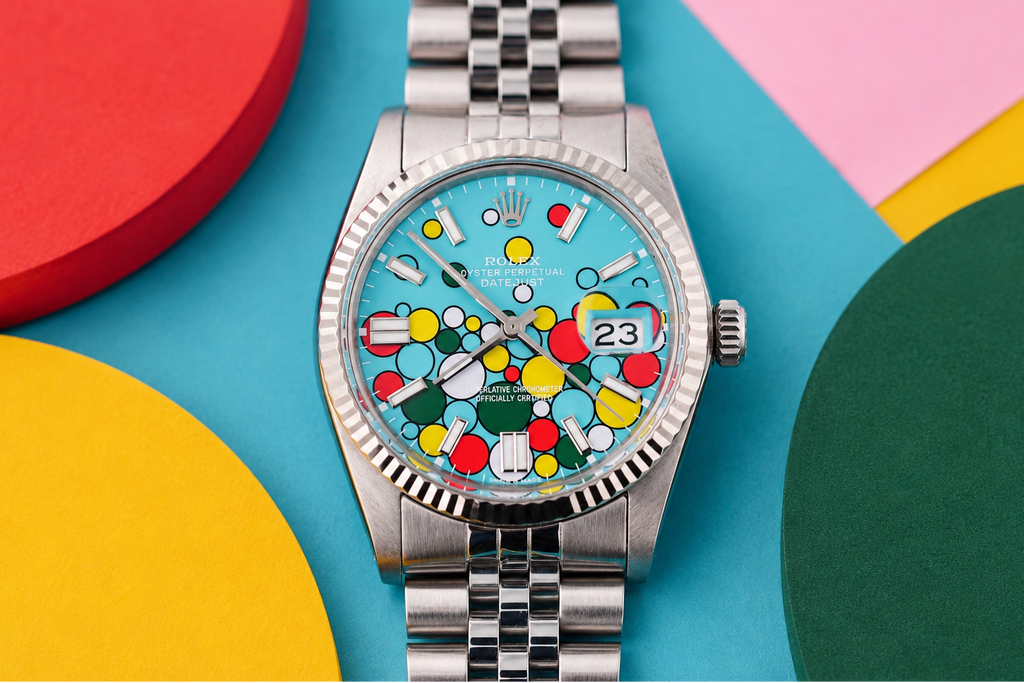 Silver watch with a colorful face on a multicolored geometric background