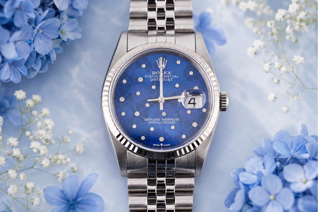Silver watch with blue face on a floral background