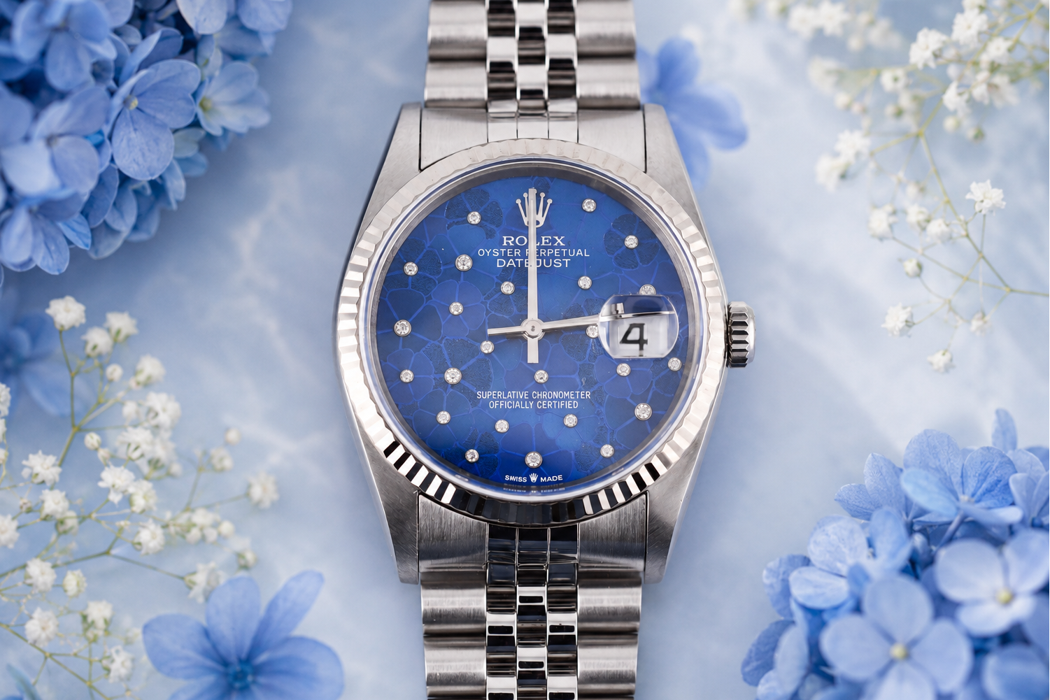 Silver watch with blue face on a floral background