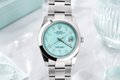 Silver watch with a turquoise dial on a light background