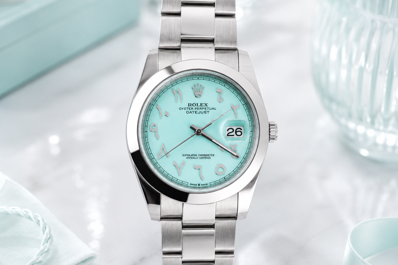 Silver watch with a turquoise dial on a light background