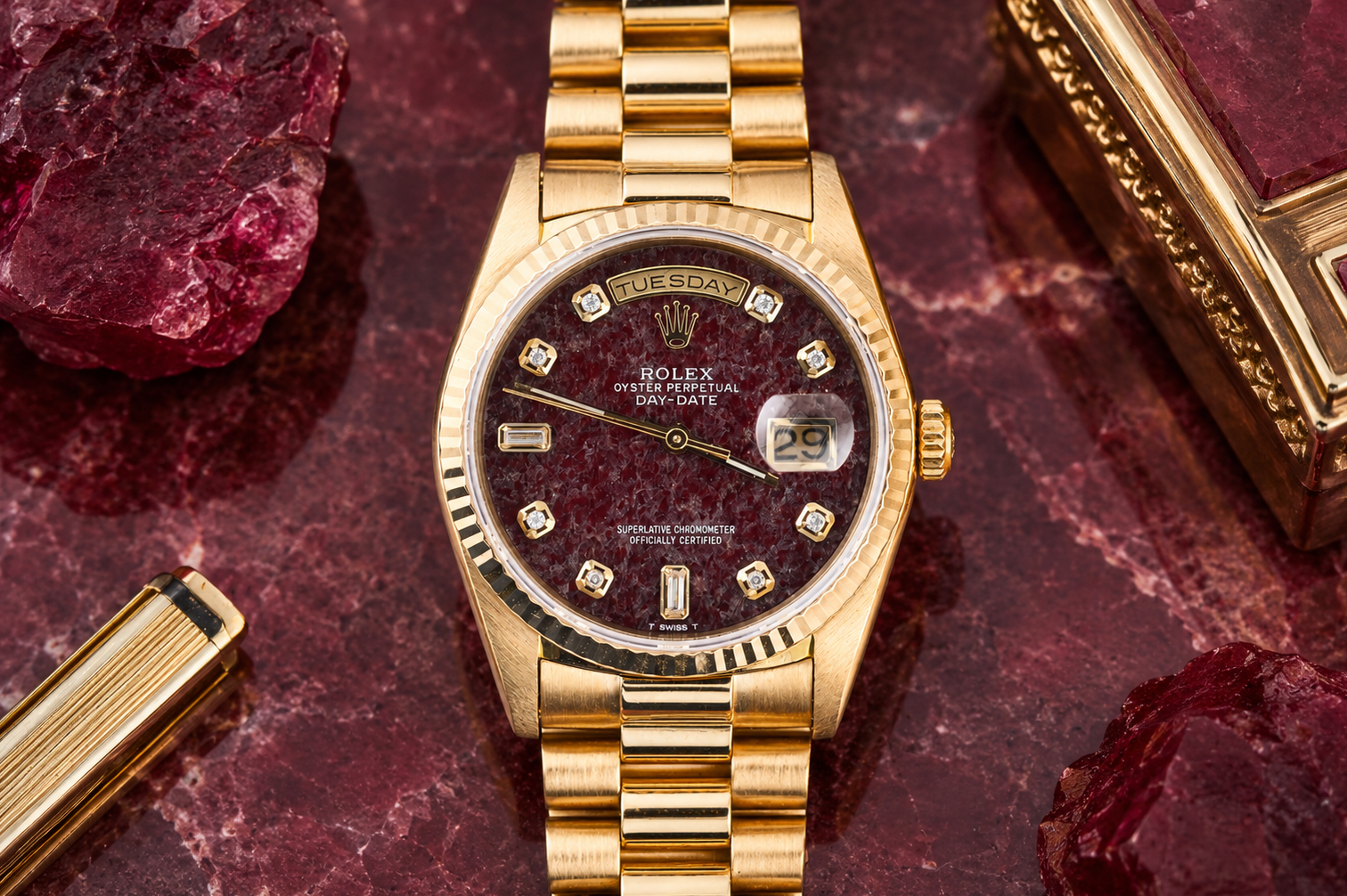 Gold wristwatch with a dark face on a red marbled surface
