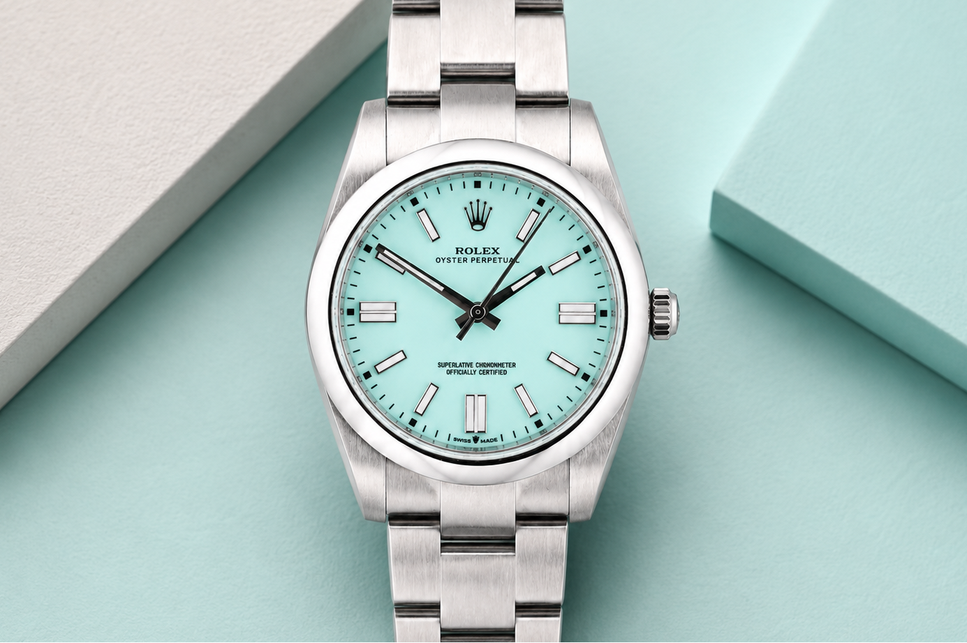 Silver watch with a turquoise dial on a light blue background