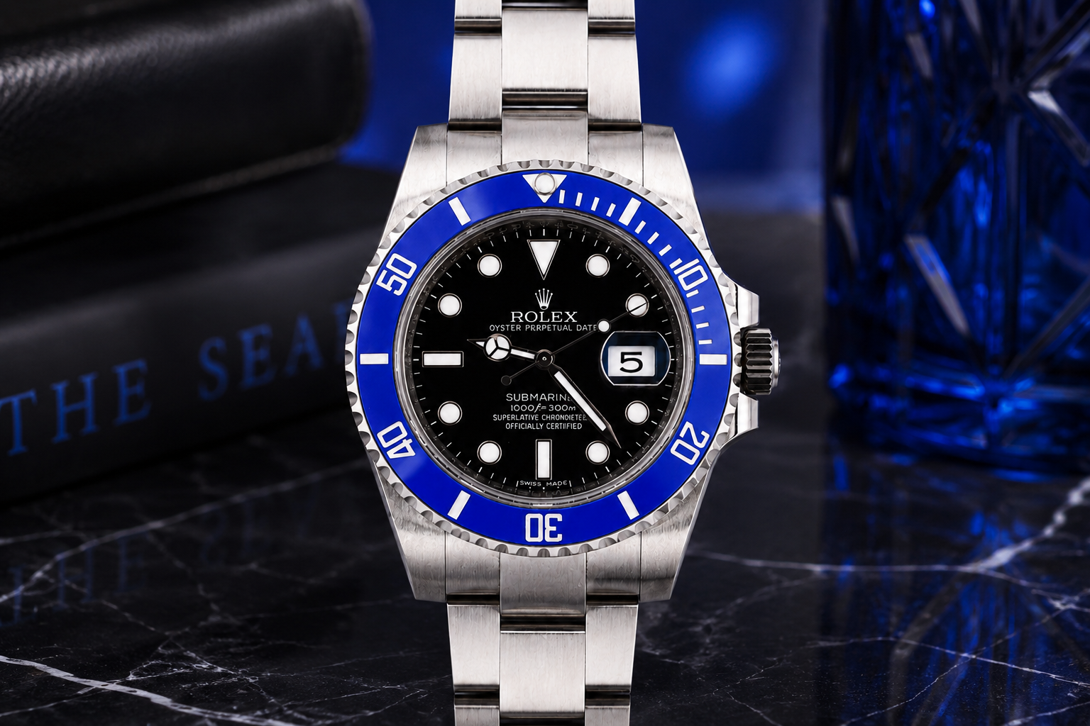 Silver watch with blue bezel on a dark background