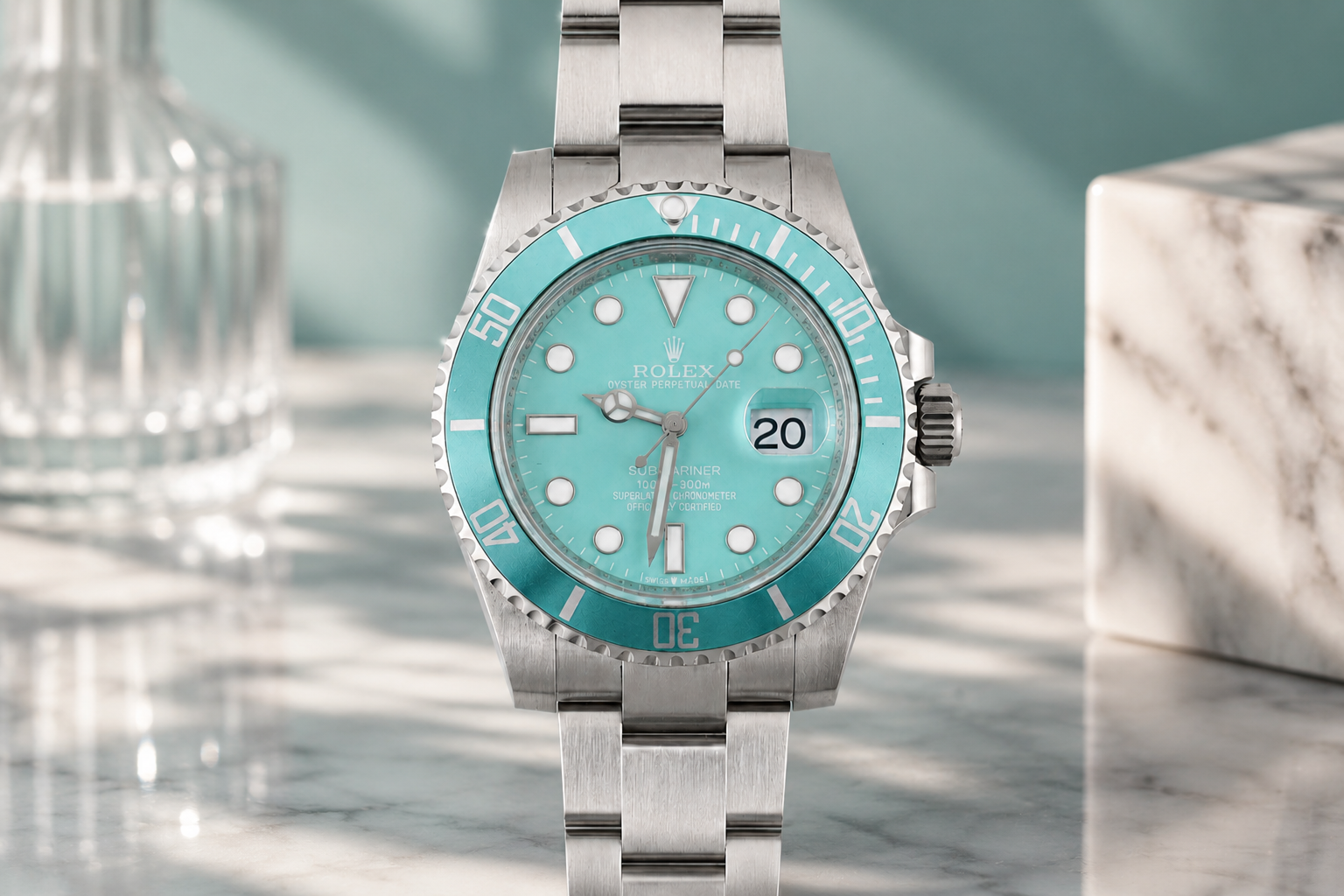 Silver watch with turquoise dial on a marble surface