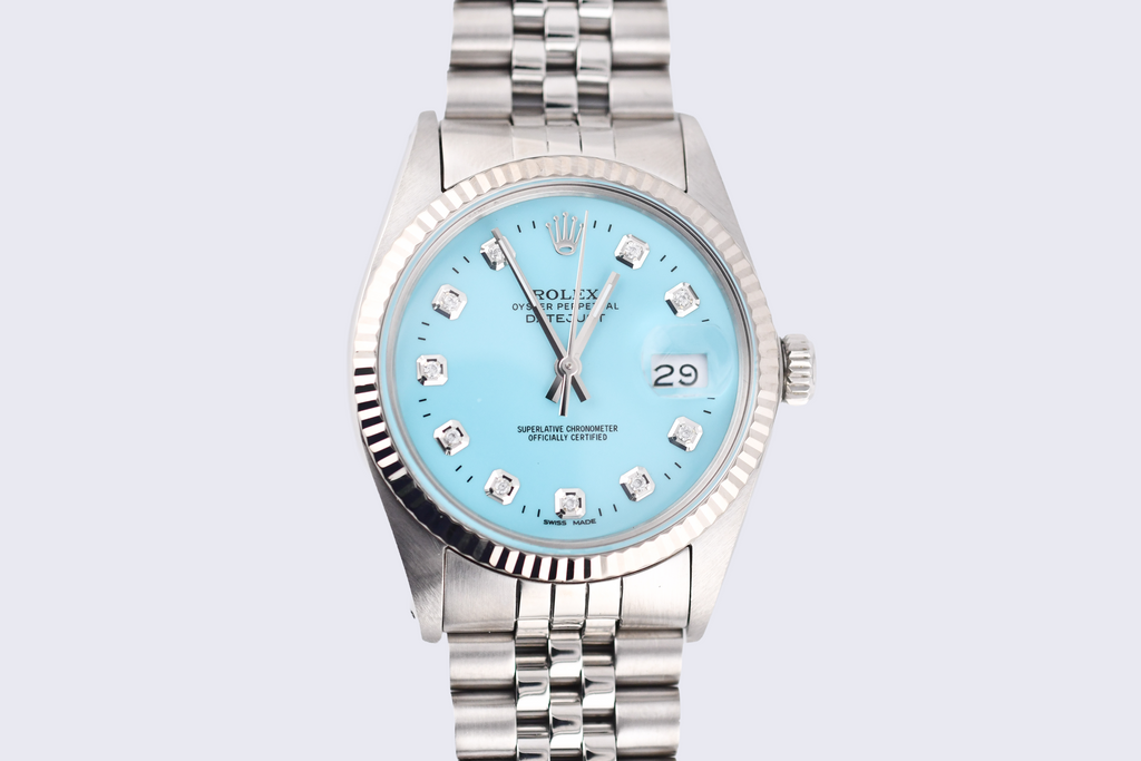 Silver watch with a light blue dial on a light gray background