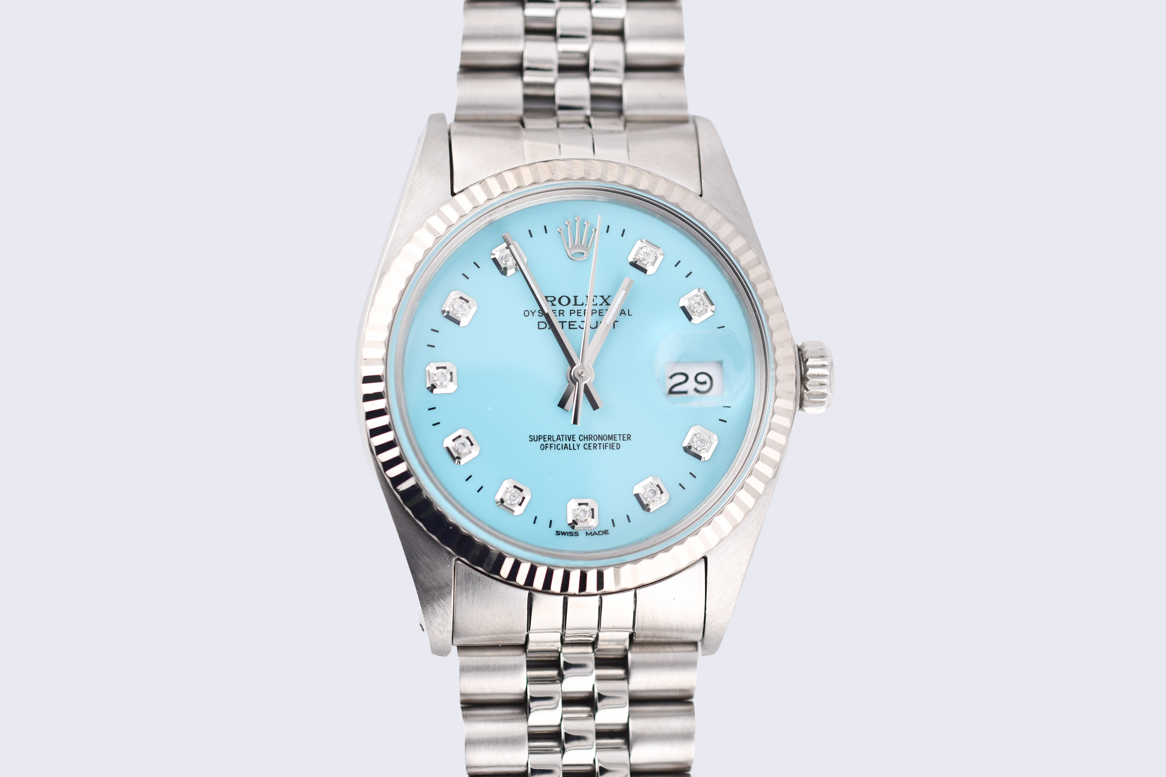 Silver watch with a light blue dial on a light gray background