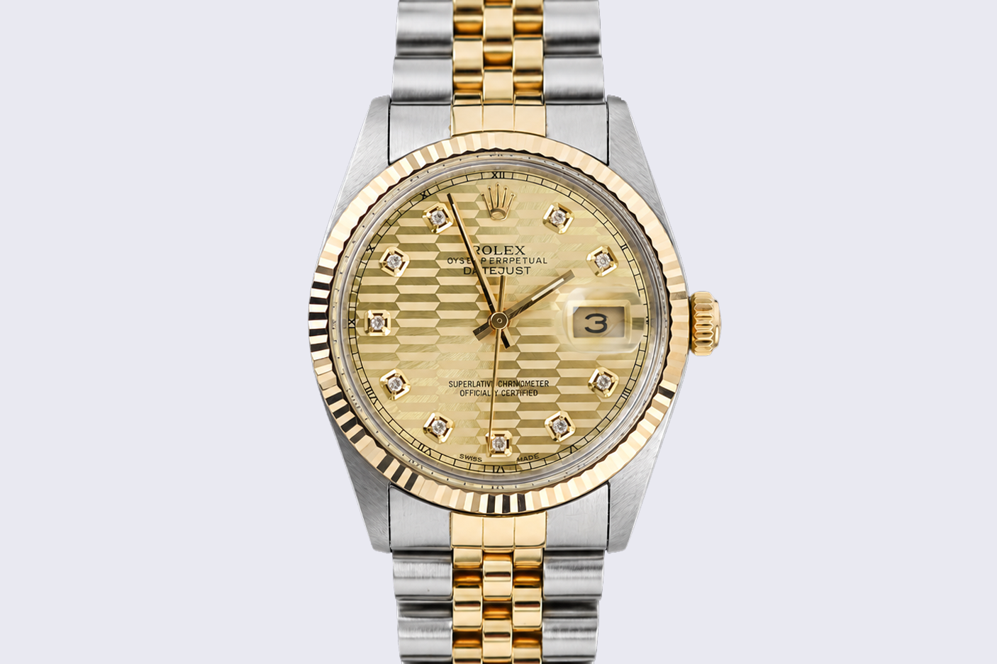 Gold and silver watch with a detailed face on a light gray background