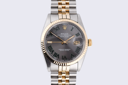 Luxury watch with silver and gold band on a light gray background