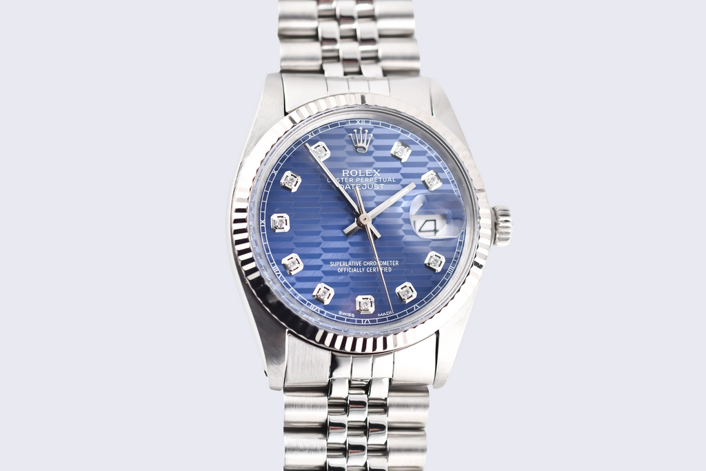 Silver watch with a blue face on a light gray background