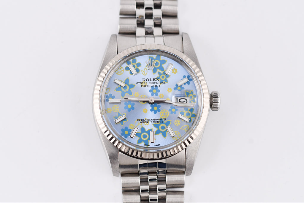 Silver watch with a floral patterned face on a white background