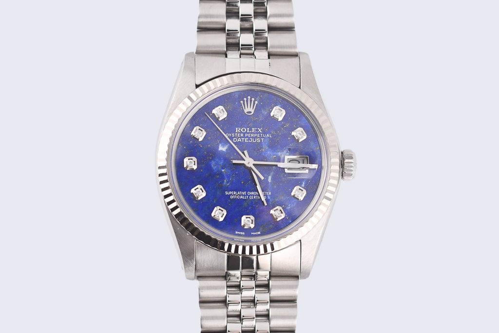 Silver watch with a blue face on a light gray background