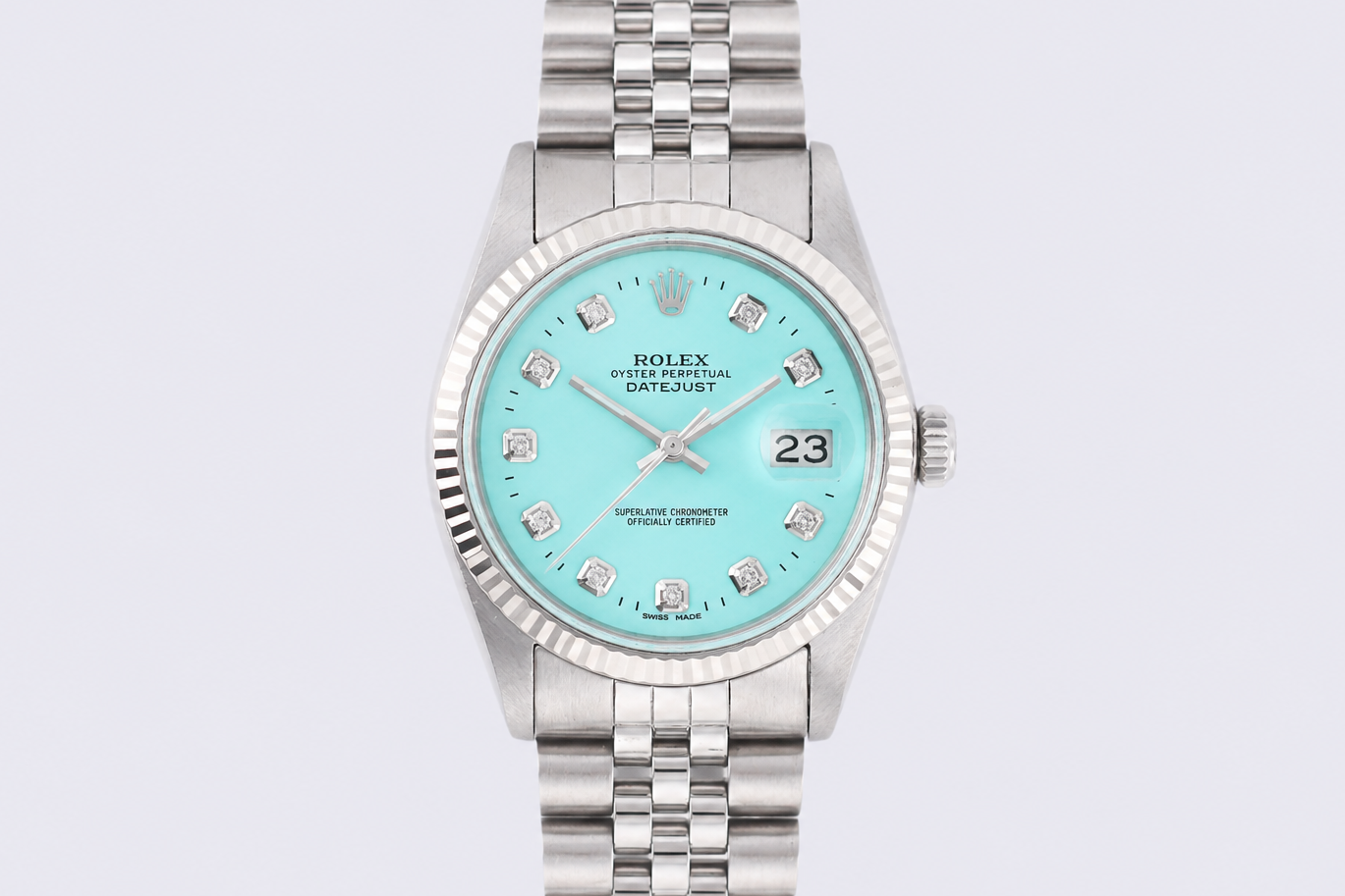 Silver watch with a turquoise dial on a light gray background