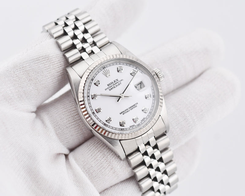 Silver watch with a white face on a light gray background