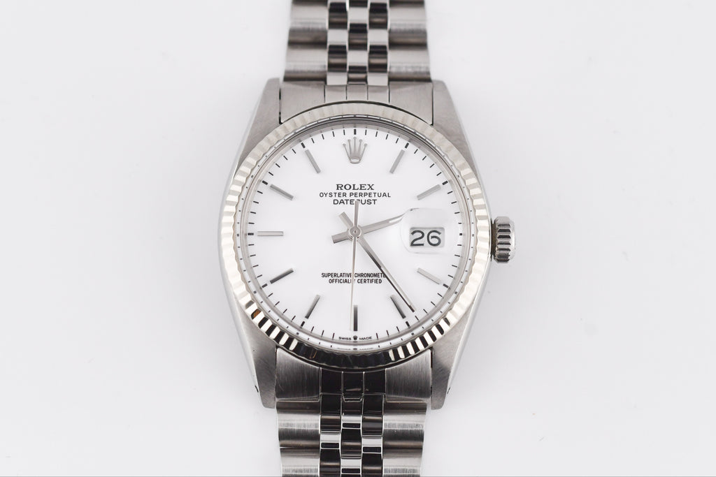 Silver watch with a white face on a light gray background