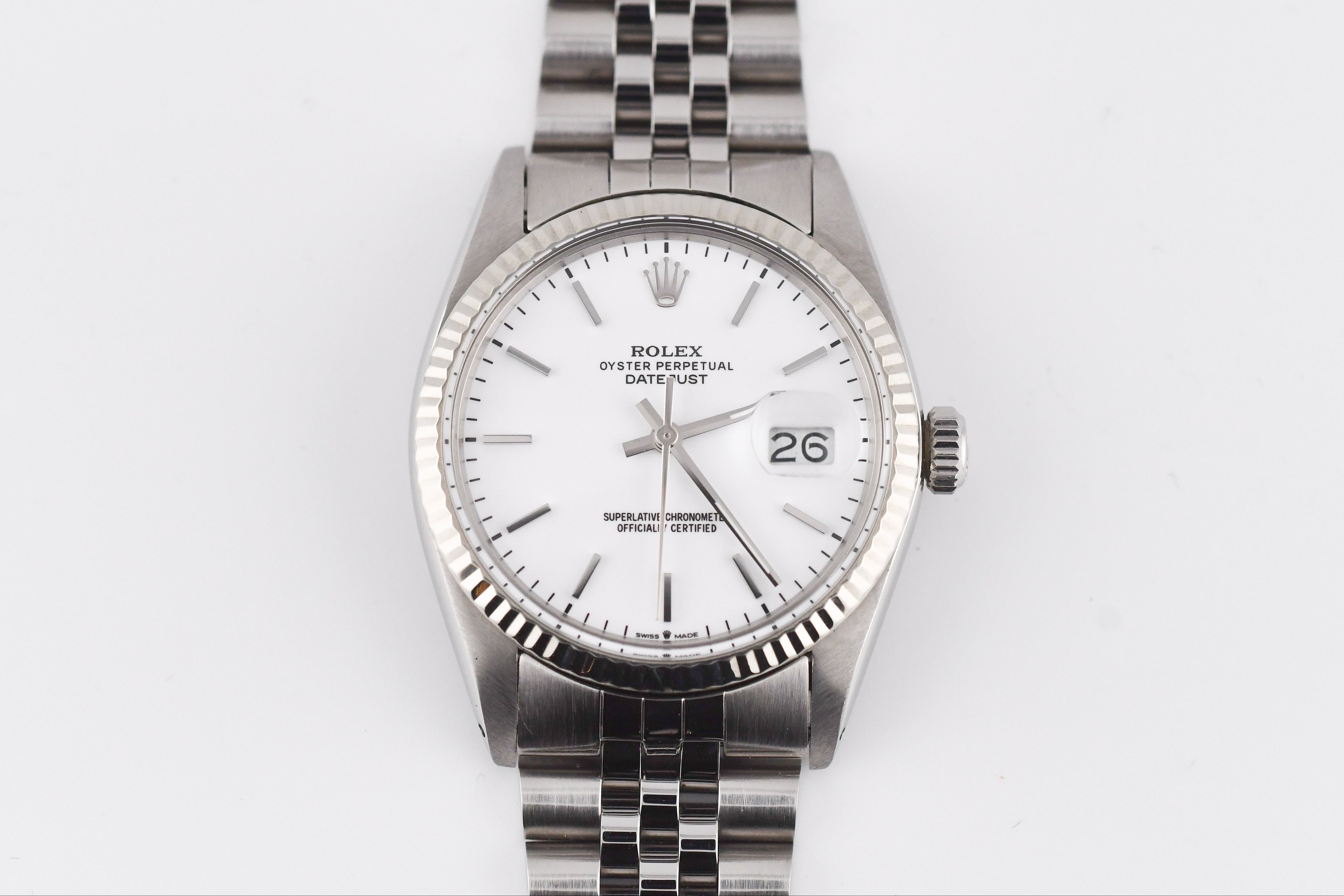 Silver watch with a white face on a light gray background