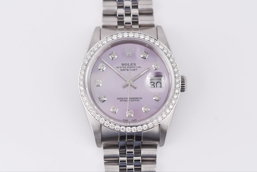 Silver watch with a purple face on a white background