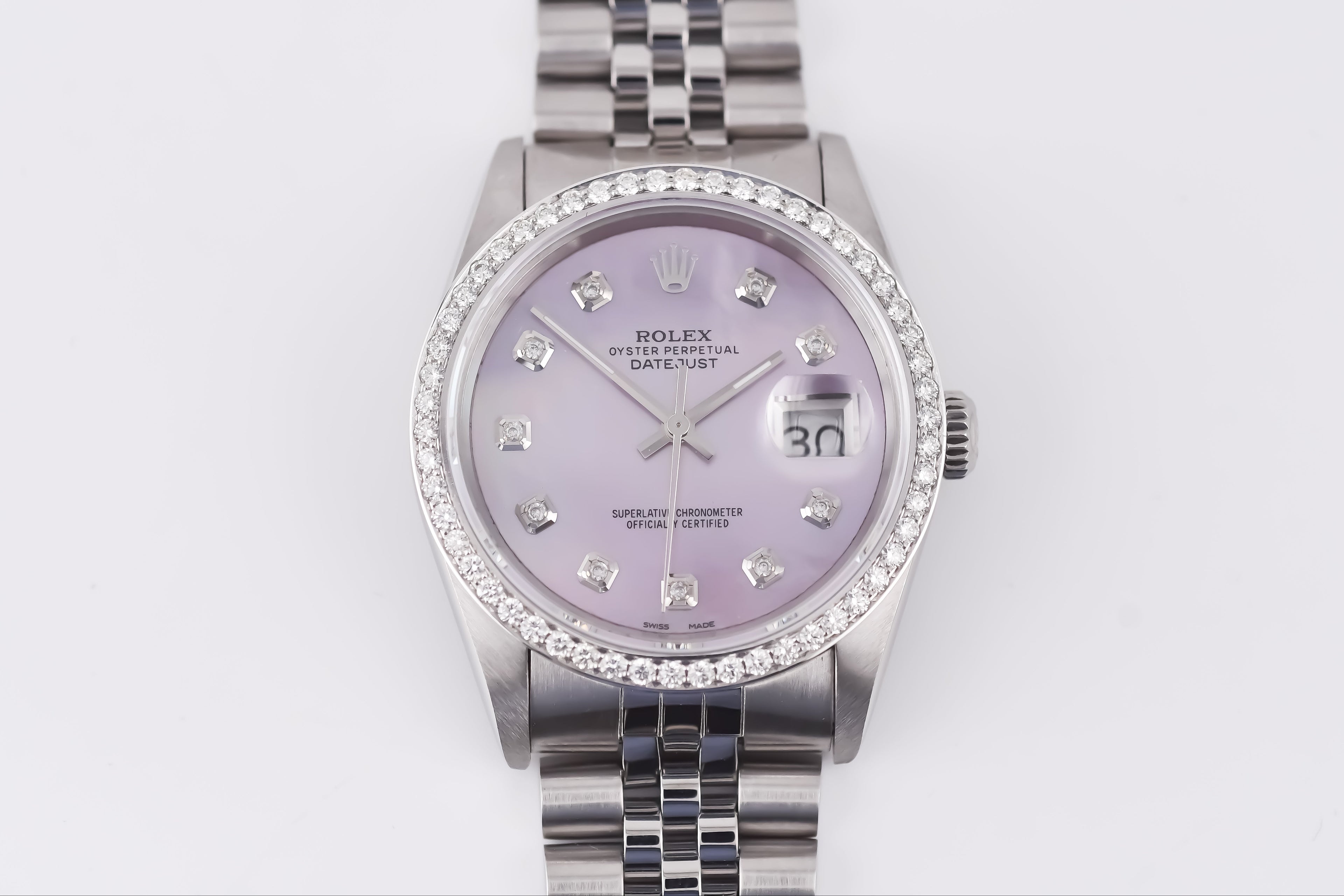 Silver watch with a purple face on a white background