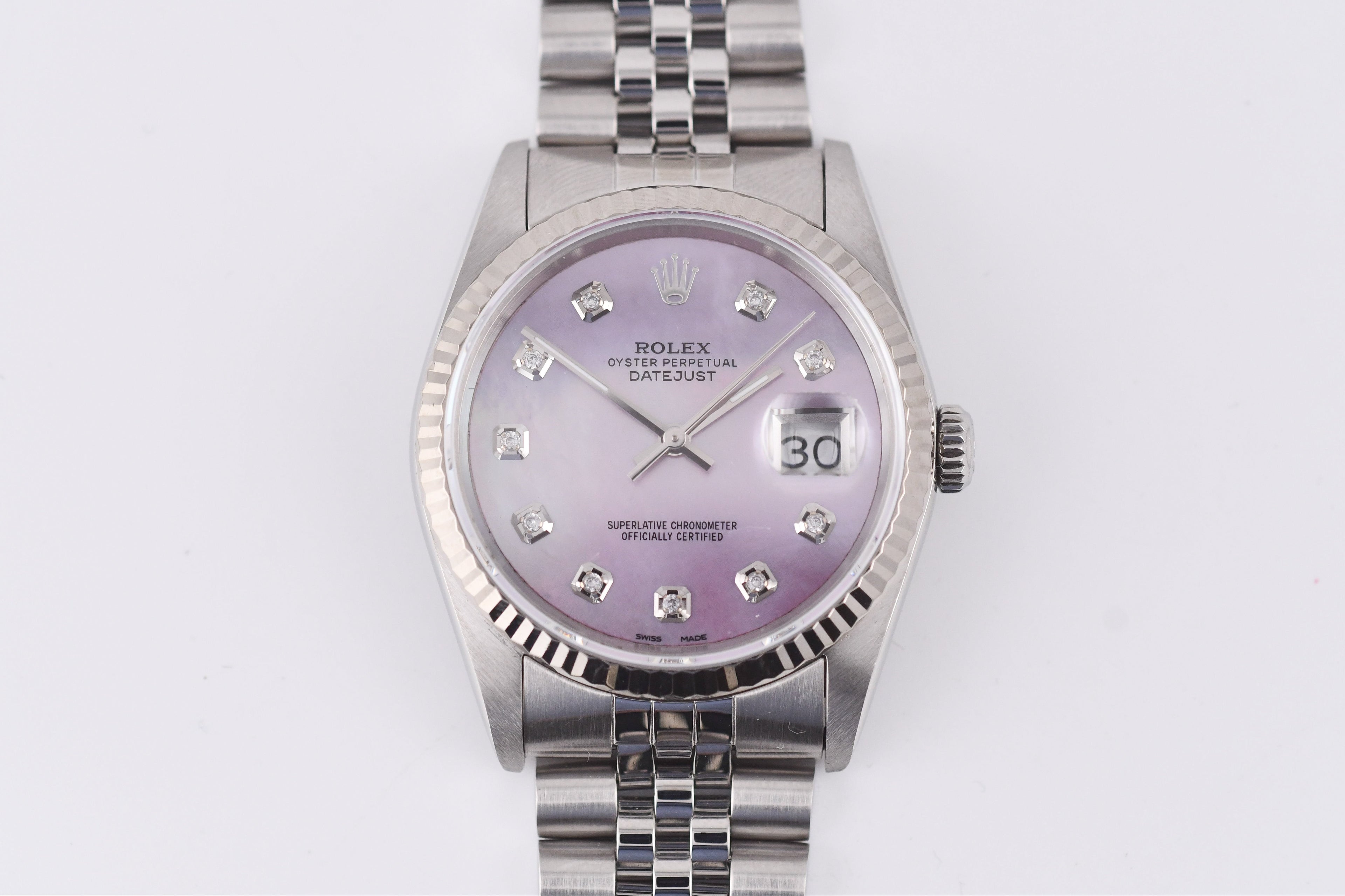 Silver watch with a purple face on a white background