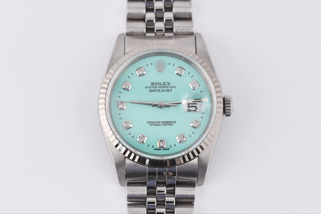 Silver watch with a turquoise dial on a white background